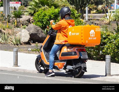 Just Eat Courier Delivery Rider In Orange Uniform And Just Eat Scooter
