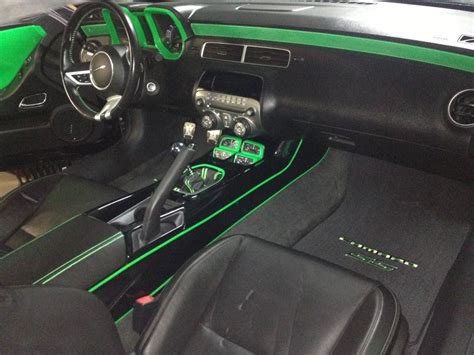 The Interior Of A Sports Car With Green Dash Lights