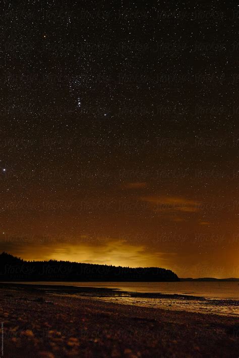 Starry Night Sky With Fading Orange Sunlight Over Forest Island By