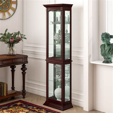 We have a curio cabinet in our living room. Astoria Grand Watkin Floor Standing Lighted Curio Cabinet ...