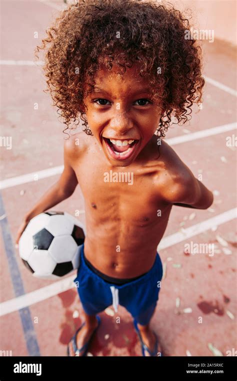 Portrait Of A Boy Holding A Soccer Ball Standing On A Soccer Field