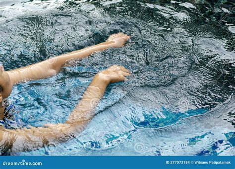 asian woman swims with her arms because she is about to drown and her legs cramp in the swimming