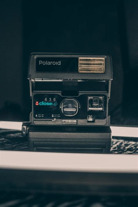 Vintage analog camera on table in dark studio · Free Stock Photo