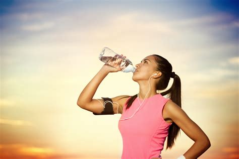 Smiling Female Runner Holding A Bottled Water Hoodoo Wallpaper