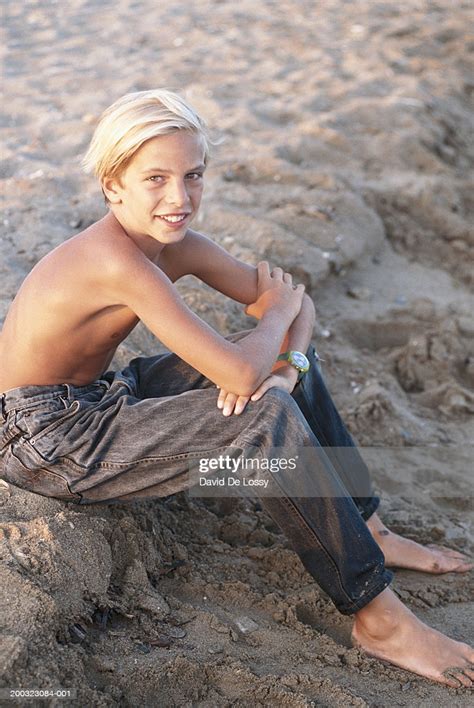 Boy Sitting On Beach Elevated View High Res Stock Photo