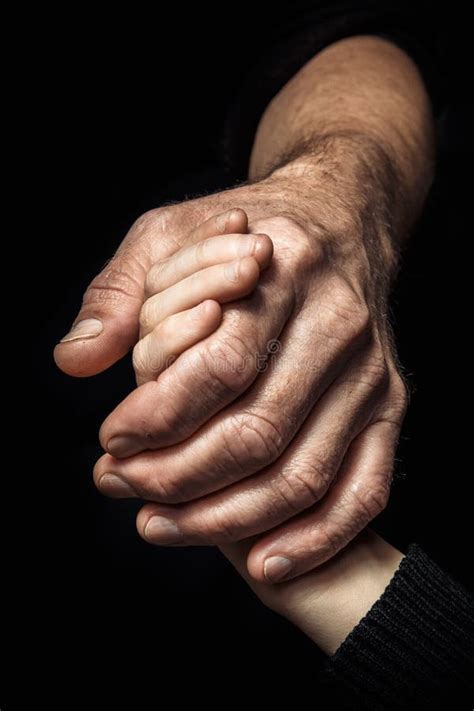 Hands Of An Elderly Man Holding The Hand Of A Younger Man Stock Image