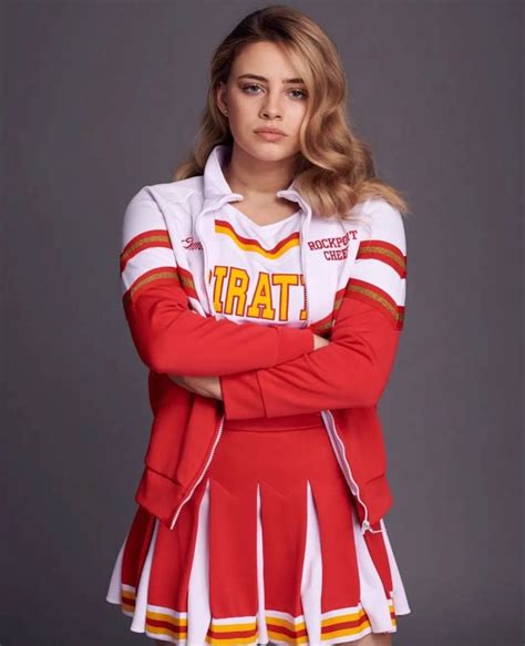 A Woman In A Cheerleader Outfit Posing For A Photo With Her Arms