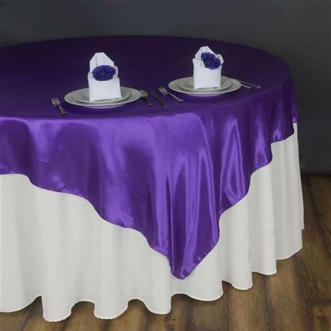 The Table Is Covered With Purple And White Linens