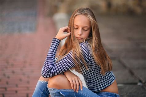 Jeunes Poses Adolescentes Au Photographe Fille Blonde Dans Les Jeans Et Le Chemisier Image Stock