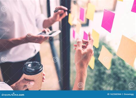 Business People Meeting At Office And Use Sticky Notes On Glass Wall In