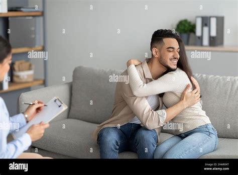 loving arab couple hugging in counselor s office after successful marital therapy embracing