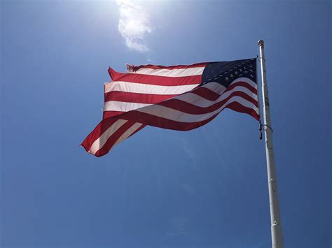 wallpaper id 269296 american flag flying in the wind against a sunny blue sky worn flag 4k