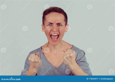 Angry Young Woman With Fists Up Screaming Isolated On Bright Green Gray