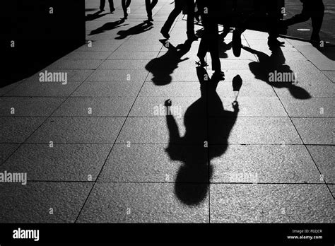 Shadows And Silhouettes Of People Walking On Street In City Stock Photo
