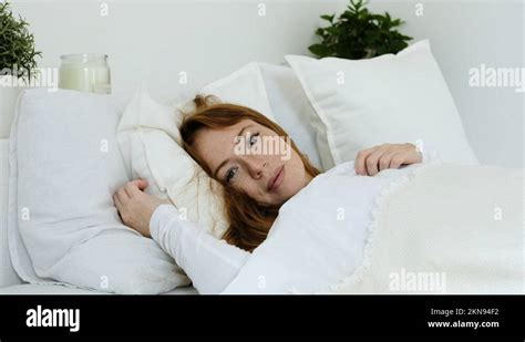 Beautiful Sleeping Female Wakes Up In Bed In Morning And Opens Her Eyes
