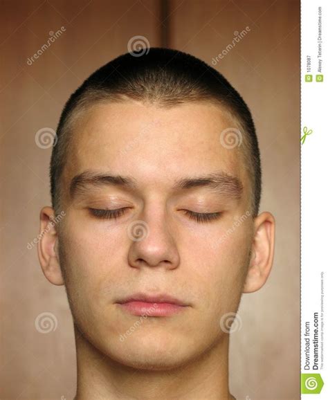 A Young Man With Closed Eyes Is Looking At The Camera And Has His Eyes