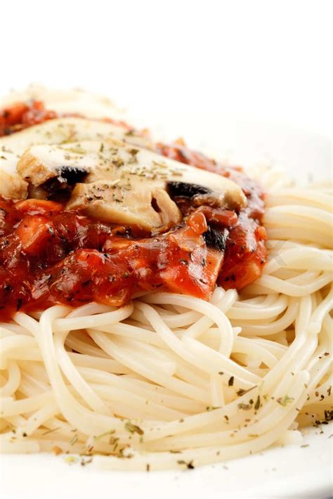 Spaghetti mit Tomaten Sauce und Champignons auf weißem Teller