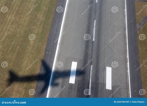 Aircraft Shadow After Takeoff On Ground Over Airport Runway With Green