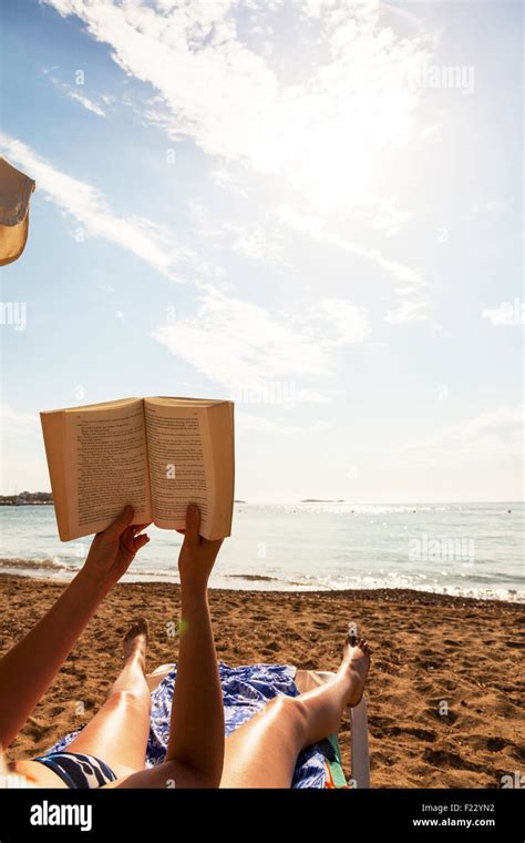 Reading Book On Beach Holiday Read In Sun Sunshine Woman Sunbathing Against Sky Open Pages Stock