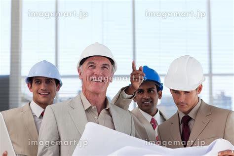 A Group Of Architects Discussing A Construction Plan In A Buildingの写真素材