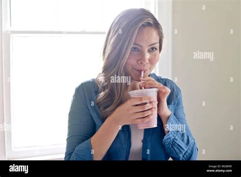 Portrait Of Young Woman Drinking Through Straw Stock Photo Alamy