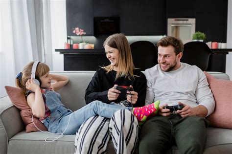 Free Photo Cheerful Parents Playing Video Games Near Daughter