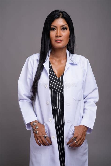 Mature Beautiful Asian Woman Doctor Against Gray Background Stock Image