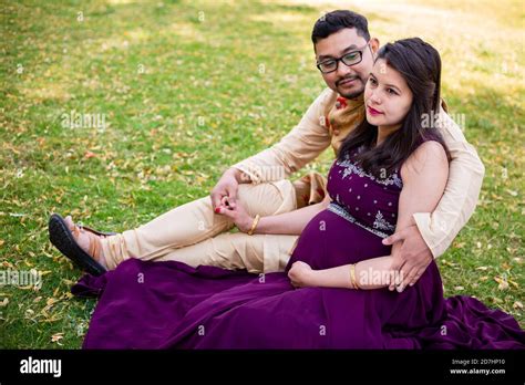 Young Asian Indian Pregnant Woman With Her Husband In Sitting Relaxing In Park Or Garden Young