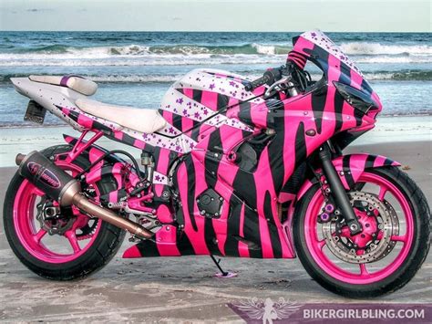A Pink And Black Motorcycle Parked On The Beach