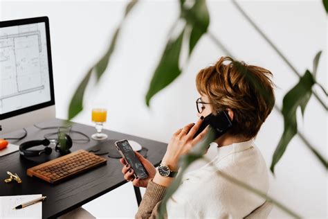 Busy Female Talking On Smartphone And Checking Messages During Work In