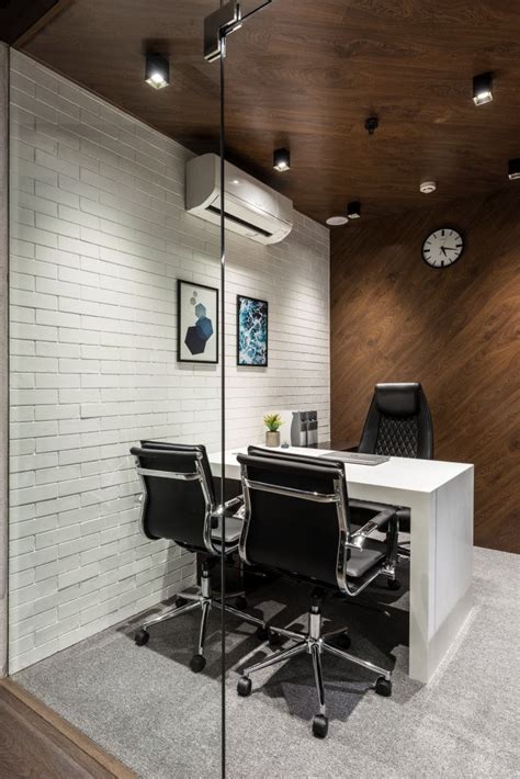 An Office With White Brick Walls And Black Leather Chairs Along With A