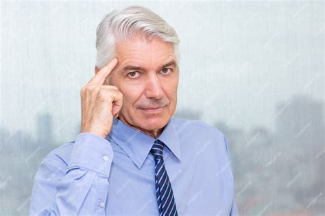 Free Photo Portrait Of Serious Businessman Pointing At Head