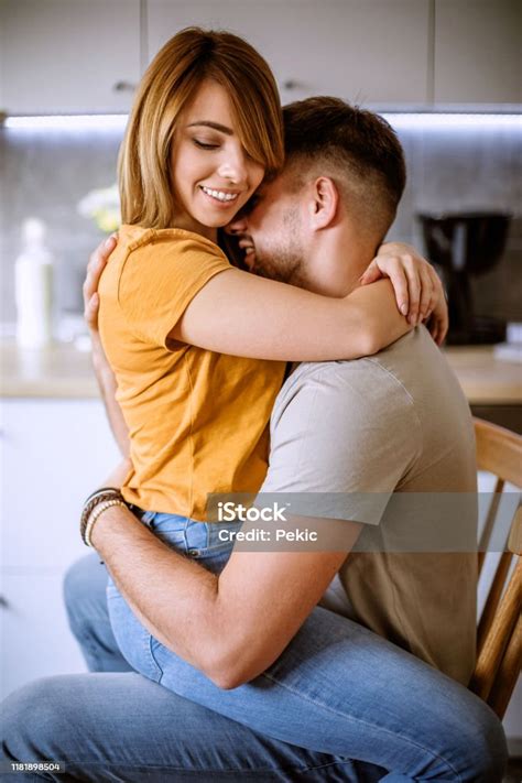 Woman Sitting In Boyfriends Lap And Embracing Stock Photo Download