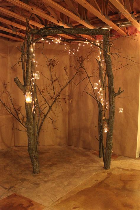 Arch Made From Small Tree Trunks And Branches Used White Lights And
