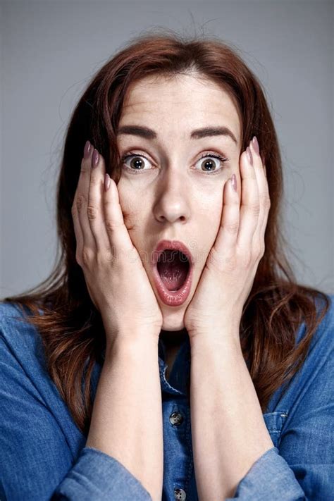 Portrait Of Young Woman With Shocked Facial Expression Stock Photo