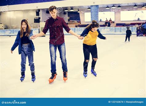 Grupo De Patinagem No Gelo Adolescente Dos Amigos Em Uma Pista De Gelo
