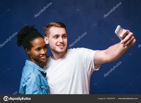 homem branco e mulher negra fazer selfie diversão e alegria fotos imagens de © golubovystock