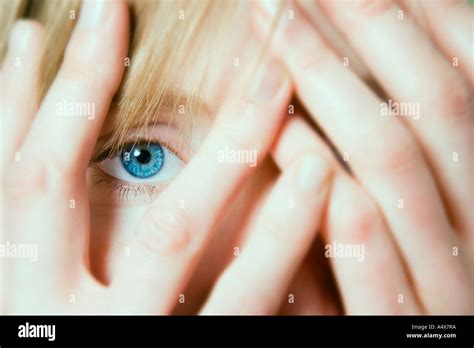 Young Woman Peeking Through Hands Over Face Close Up Stock Photo Alamy
