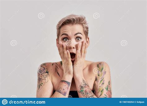 Amazement Portrait Of Amazed Tattooed Woman With Short Hair Looking Amazed Or Shocked At Camera