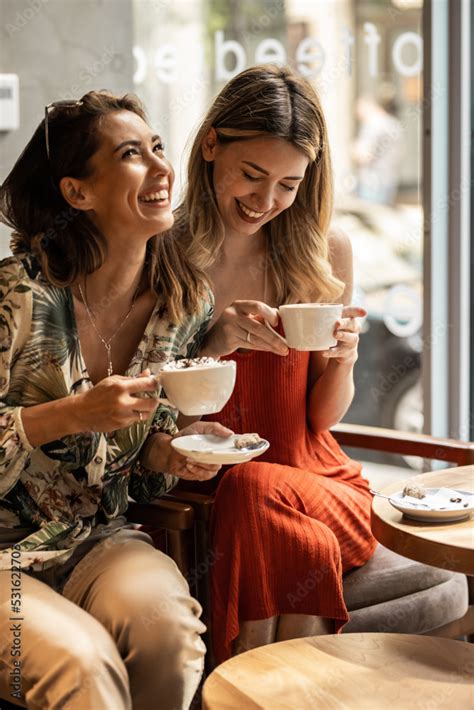 Beautiful Happy Women Talking And Laughing While Drinking Coffee