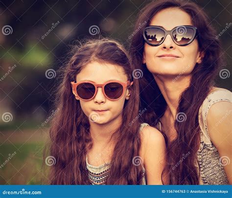 Happy Fashion Mother Embracing And Her Daughter In Trendy Sunglasses On Nature Summer Background