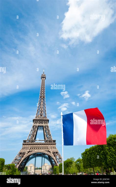 Drapeau Français Volant Dans Ciel Bleu En Face De La Tour Eiffel à