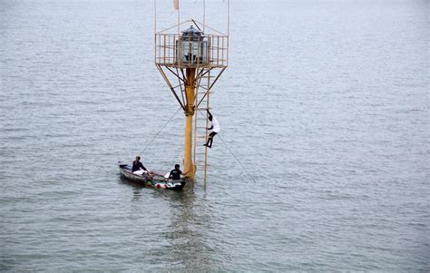 Hindu Priest Climbs Down A Ladder After Lighting An Oil Lamp In