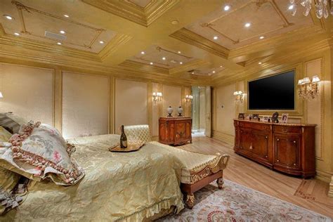 luxurious master bedroom with gold decor chaise lounge and rich wood furniture parisian