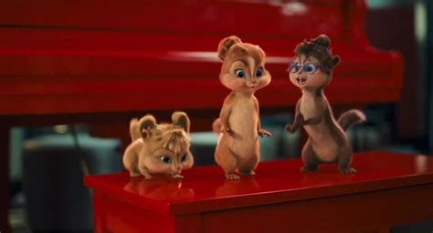 The Chipmuns Are Standing On Top Of A Red Table With A Piano In The Background
