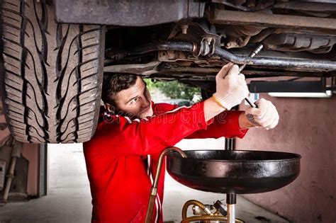 Professional Handsome Male Car Mechanic In Uniform Working Under Stock