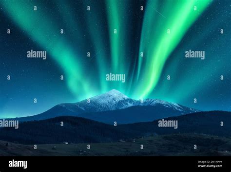 Aurora Borealis Over The Snow Covered Mountain Peak Stock Photo Alamy