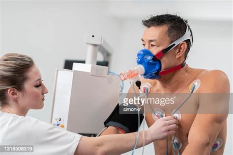 Female Nurse Placing Electrodes On The Chest Of A Man High Res Stock