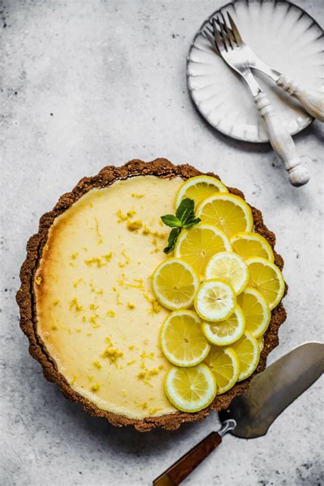 A Lemon Tart On A Plate With A Knife And Fork
