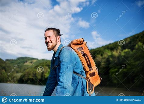 Young Tourist Man Traveller With Backpack Standing In Nature Resting